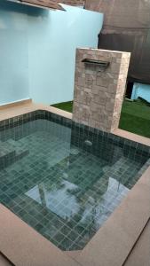 a pool with a stone fireplace in a backyard at Sea Shades Palolem Resort in Palolem