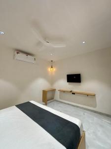 a bedroom with a bed and a tv on the wall at The Hyde Park Inn in Bilāspur