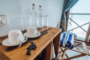 ein Holztisch mit zwei Glasflaschen und Untertassen in der Unterkunft ZAN Tropical Jambiani Beach in Bwejuu