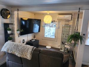 a living room with a couch and a flat screen tv at Villa salonkylä in Joensuu