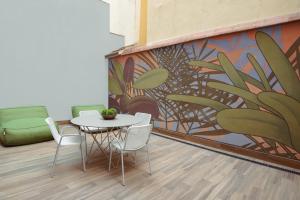a table and chairs in a room with a mural at Líbere Madrid Malasaña in Madrid