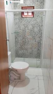 a bathroom with a toilet and a shower at Kitnets Caribe Maragogi Peroba in Maragogi