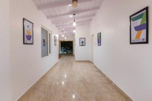 a hallway with white walls and paintings on the walls at Treebo Green Oak in Nainital