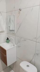a bathroom with a toilet and a sink and a mirror at Kitnets Caribe Maragogi Peroba in Maragogi