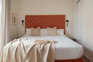 a bedroom with a large bed with a red headboard at Líbere Madrid Malasaña in Madrid +31 photos