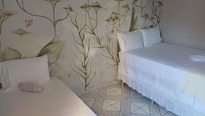 een slaapkamer met een bed en een muur met bloemen bij Suite Africana Aracaju in Aracaju