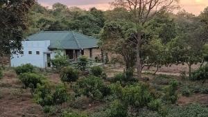 a white house in the middle of a field at One More Night Hostel in Sigiriya
