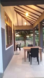 a patio with a wooden table and chairs on a house at One More Night Hostel in Sigiriya