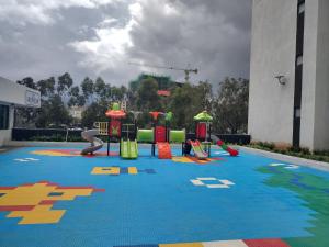 a playground with colorful equipment on a blue carpet at Serenity Apartment Artesano in Nairobi