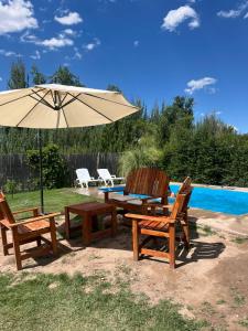 a table and two chairs under an umbrella next to a pool at Cortaderas de La Villa-San Rafael in San Rafael