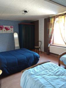 a bedroom with two blue beds and a window at gite chez Maise in Le Val-dʼAjol
