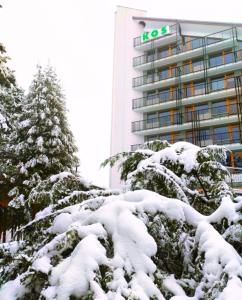 a hotel with snow covered trees in front of a building at Sanatorium Kos in Ustroń