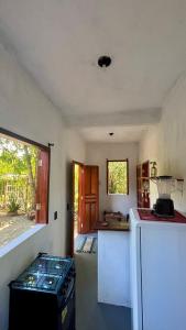 a kitchen with a stove and a refrigerator at Taboca Chalé na Rua do Serrão in Cairu +8 photos