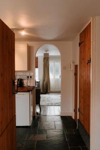 an open hallway with a kitchen and an archway at River Cottage in Beccles