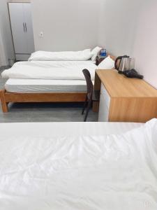 two beds in a room with a desk and a bed at Trần Hưng Đạo 186 in Na Ngô +4 photos