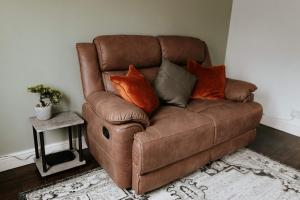 a brown couch with pillows on it in a room at River Cottage in Beccles +30 photos