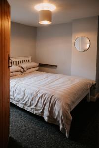 a bedroom with a large white bed with a mirror at River Cottage in Beccles