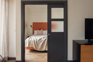 a bedroom with a bed and a black door at Líbere Madrid Malasaña in Madrid