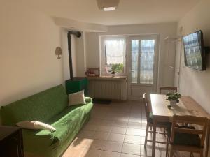 ein Wohnzimmer mit einer grünen Couch und einem Tisch in der Unterkunft Appartamento Ape Verde in Piano dʼArta