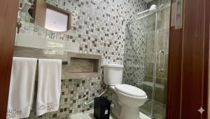 a bathroom with a toilet and a glass shower at Sun Route Hotel in Cabo de Santo Agostinho +50 photos