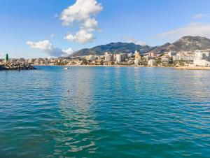 ein großer Wasserkörper mit einer Stadt im Hintergrund in der Unterkunft B&F Paloma in Benalmádena