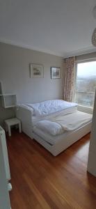 a white bed in a room with a window at Dunslair View Appartment in Peebles