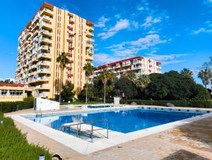 una piscina di fronte a un edificio alto di B&F Paloma a Benalmádena