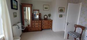 a room with a wooden dresser and a mirror at Dunslair View Appartment in Peebles