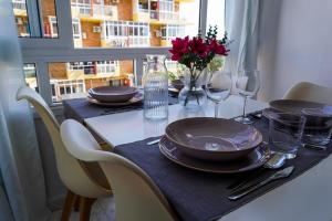 einen Tisch mit Tellern, Weingläsern und Blumen darauf in der Unterkunft B&F Paloma in Benalmádena