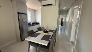 a kitchen with a table with chairs and a refrigerator at Cód 2 - Cobertura de 2 dormitórios na Praia Grande in Rodeio