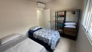 a bedroom with two beds and a shelf with pillows at Cód 2 - Cobertura de 2 dormitórios na Praia Grande in Rodeio +18 photos