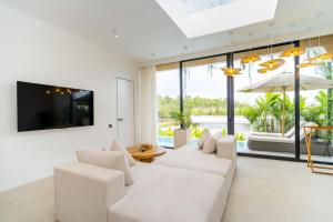 a living room with two white couches and a tv at Ardhana Villas - Luxury Pool Stay with Scenic Views in Ungasan +156 photos