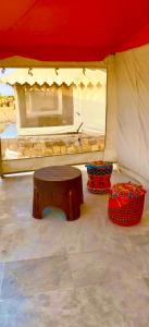 een rood-witte tent met een tafel en manden bij K R Desert Resort in Dedha