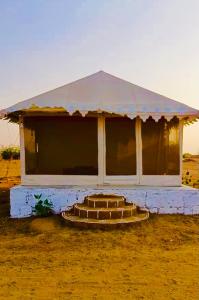 een klein gebouw midden in een veld bij K R Desert Resort in Dedha +4 foto's