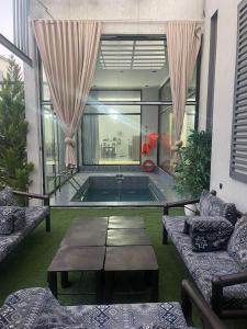 a living room with a pool with a table and chairs at شاليهات ريف الوادي in Taif