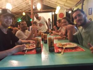 a group of people sitting at a table eating pizza at One More Night Hostel in Sigiriya +13 photos