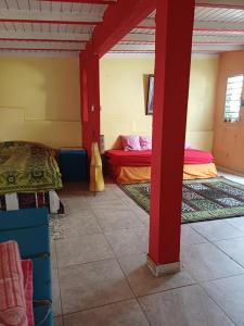 een kamer met 2 bedden en een rode paal bij Chez Brahim in Pointe-à-Pitre +10 foto's