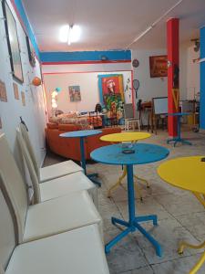 een kamer met 2 tafels en stoelen en een bank bij Chez Brahim in Pointe-à-Pitre