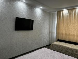 ein Zimmer mit einem Flachbildfernseher an der Wand in der Unterkunft George's Apartaments in Donduşeni