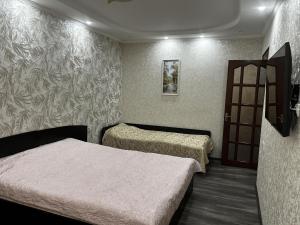 ein Zimmer mit zwei Betten und einer Tür darin in der Unterkunft George's Apartaments in Donduşeni