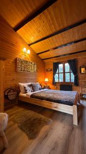 a bedroom with a large bed in a wooden room at Montebello Chalet in Porumbacu de Sus +107 photos