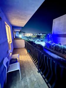een balkon met een tafel en stoelen 's nachts bij LuRo Loft Otopeni in Otopeni