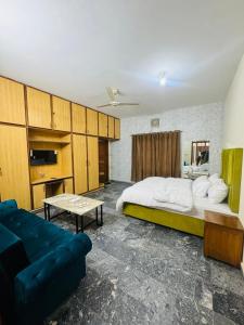 a bedroom with a large bed and a couch at Hotel living spot in Lahore