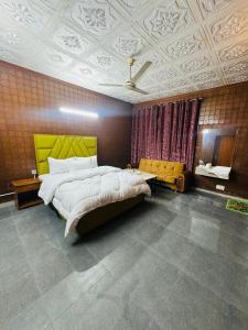a bedroom with a large bed with a yellow headboard at Hotel living spot in Lahore