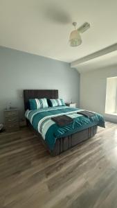 a bedroom with a large bed with blue sheets at Tipperary Town House in Tipperary