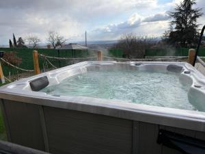 a jacuzzi tub in a yard at A-Frame Wellness Villa with Private Pool, Sauna & Jacuzzi near Belgrade in Koraćica +47 photos