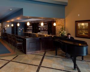 a man sitting at a bar with a piano at RiverRock Inn in Rockland