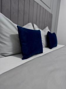 een bed met twee blauwe kussens erop bij LuRo Loft Otopeni in Otopeni