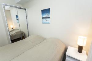 a small bedroom with a bed and a mirror at Cozy Alpine-Style Apartment in the Heart of Levi with Private Sauna & Fireplace in Levi