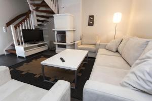 a living room with a white couch and a tv at Cozy Alpine-Style Apartment in the Heart of Levi with Private Sauna & Fireplace in Levi